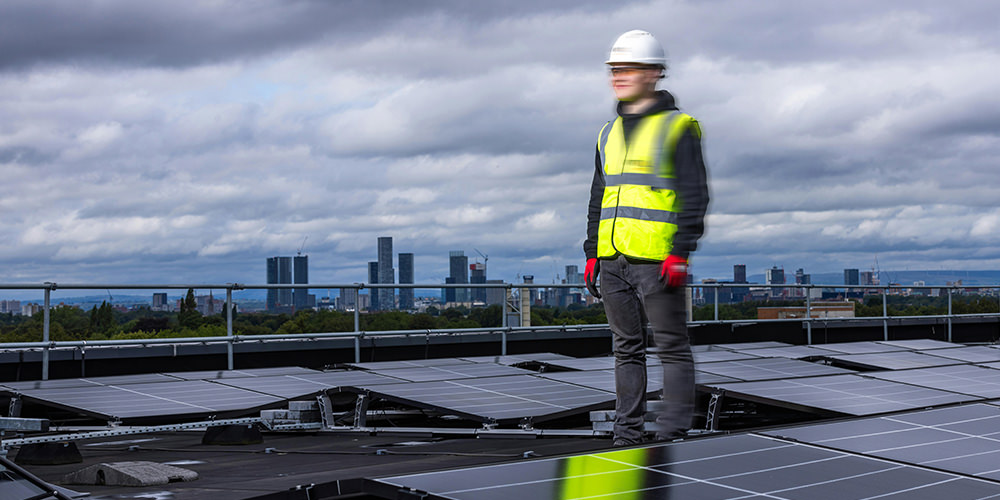 a man standing on the building roof with many solar panels